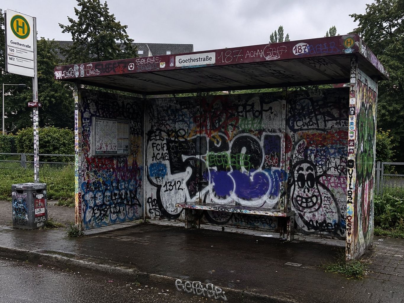 Komplett mit Graffiti besprühte Bushaltestelle – professionelle Graffitientfernung
